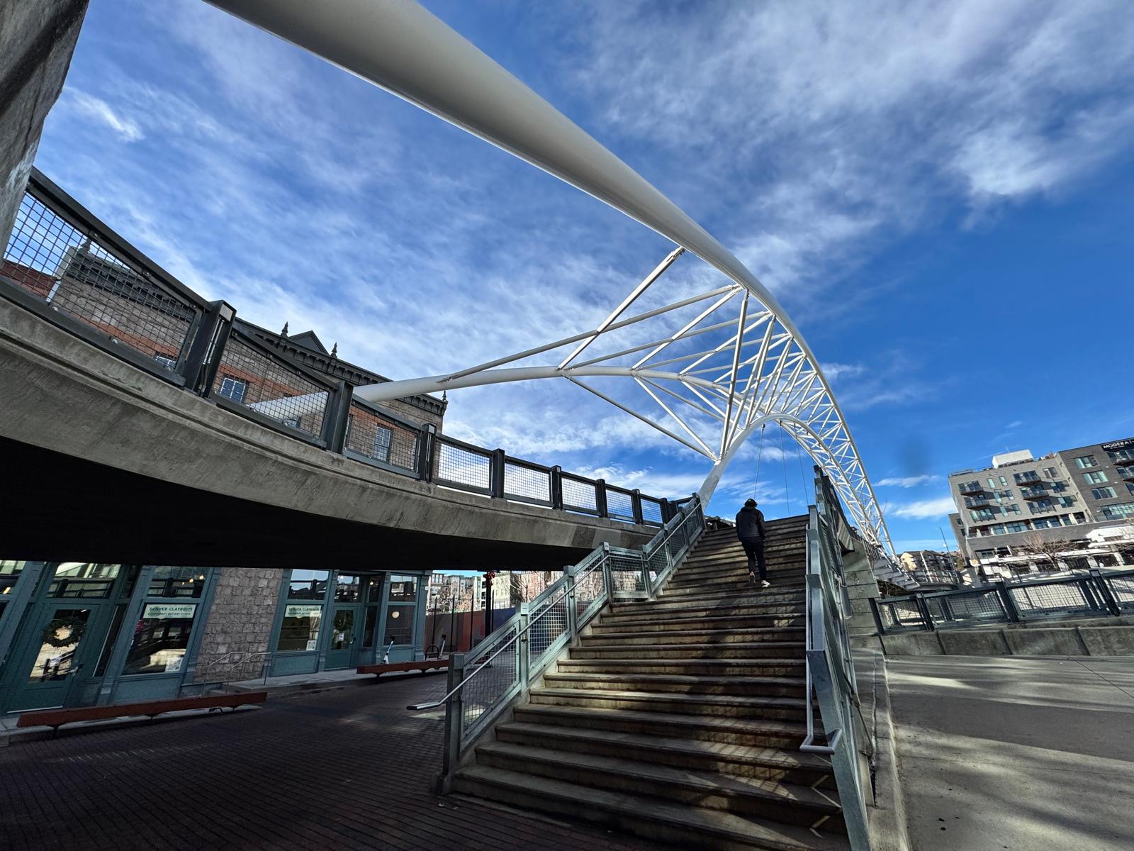 Pedestrian bridge and stairs in downtown Denver under a blue sky