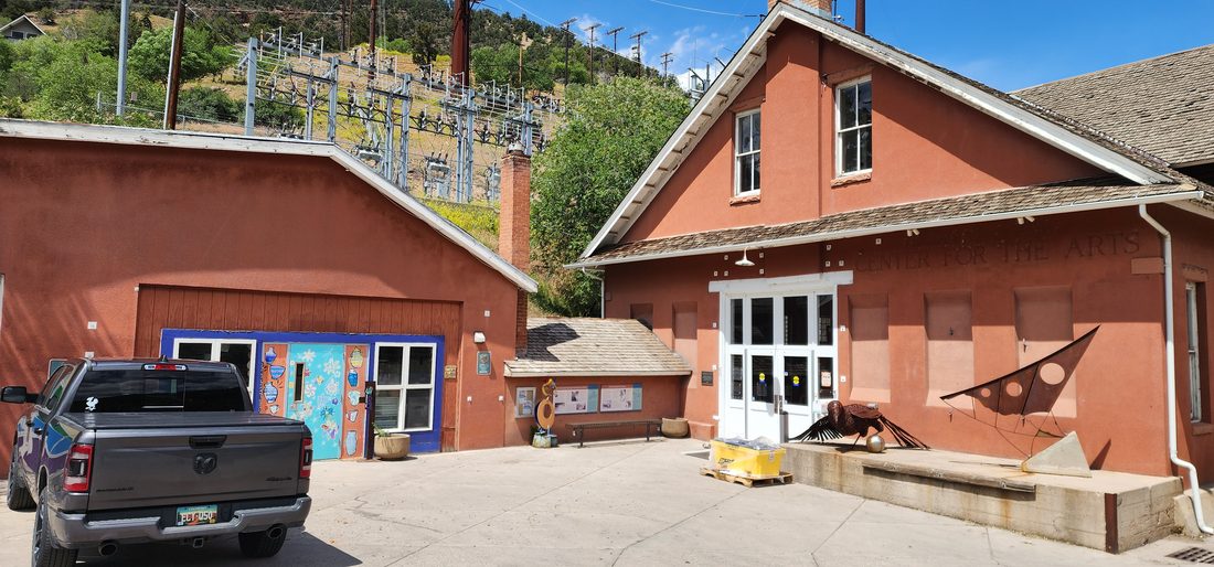 Commercial arts center building with a mural door and open roll-up door