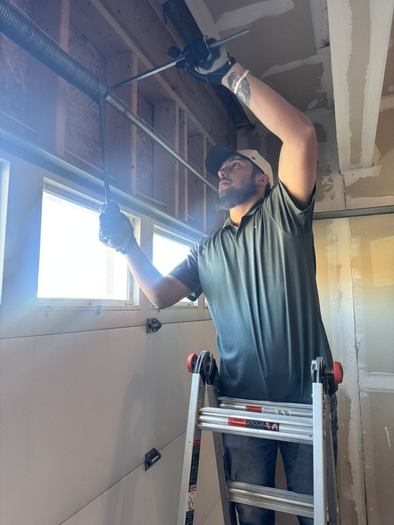 Technician adjusting the torsion spring on a residential garage door