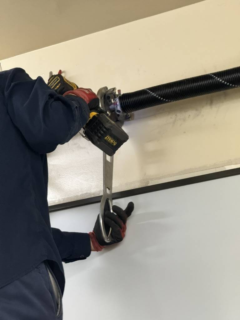 Technician winding a torsion spring