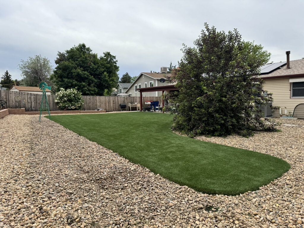 Artificial turf backyard with a river rock border